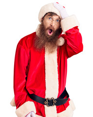 Sticker - Handsome young red head man with long beard wearing santa claus costume surprised with hand on head for mistake, remember error. forgot, bad memory concept.