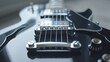   A close-up of an electric guitar with a black body and four silver pickups