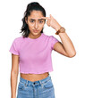 © Krakenimages.com - Hispanic teenager girl with dental braces wearing casual clothes pointing unhappy to pimple on forehead, ugly infection of blackhead. acne and skin problem