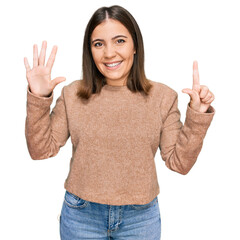 Canvas Print - Young beautiful woman wearing casual clothes showing and pointing up with fingers number seven while smiling confident and happy.