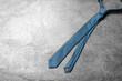 One blue necktie on grey textured background, top view. Space for text
