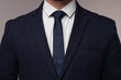 © New Africa - Businessman in suit and necktie on grey background, closeup