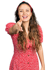 Poster - Young hispanic girl wearing casual clothes smiling friendly offering handshake as greeting and welcoming. successful business.