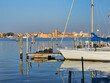 View on Chioggia from Sottomarina harbor at morning with sailboats moored alongside the docks