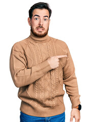 Wall Mural - Young hispanic man wearing casual clothes pointing aside worried and nervous with forefinger, concerned and surprised expression