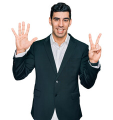 Wall Mural - Handsome hispanic man wearing business clothes showing and pointing up with fingers number seven while smiling confident and happy.