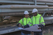 © kanpisut - Engineer survey team  checking construction project  inspection work construction site .Team Civil engineer working outdoor next to the power plant.