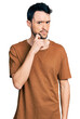 © Krakenimages.com - Hispanic man with beard wearing casual t shirt thinking concentrated about doubt with finger on chin and looking up wondering