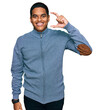 © Krakenimages.com - Young handsome hispanic man wearing casual sweatshirt smiling and confident gesturing with hand doing small size sign with fingers looking and the camera. measure concept.