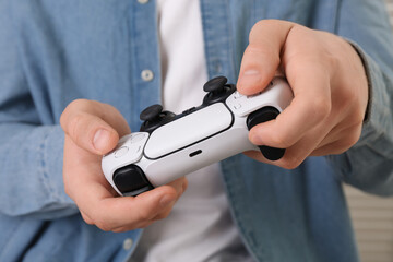 Man using wireless game controller indoors, closeup