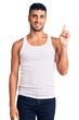 © Krakenimages.com - Young hispanic man wearing casual clothes showing and pointing up with finger number one while smiling confident and happy.