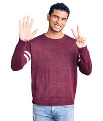 Canvas Print - Hispanic handsome young man wearing casual clothes showing and pointing up with fingers number seven while smiling confident and happy.