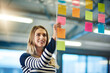 © peopleimages.com - Woman, sticky note and brainstorming solution in office as company growth or market research, glass or idea. Female person, hand and paper at creative agency or startup campaign, target or goal