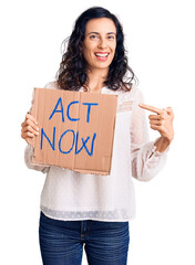 Poster - Young beautiful hispanic woman holding act now banner smiling happy pointing with hand and finger