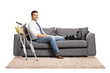 © Ljupco Smokovski - Businessman with a foot injury and leg brace sitting on a sofa