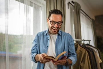 Wall Mural - Portrait of adult man read book at living room happy and relax