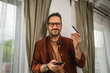 © Miljan Živković - Portrait of adult man shop online with cellphone and hold credit card