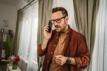 Portrait of adult nervous man stand while talk on mobile phone