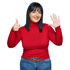 Wall Mural - Young hispanic woman wearing casual clothes showing and pointing up with fingers number six while smiling confident and happy.