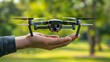 Closeup hand holding quad copter drone with digital camcorder in nature background. Generate AI
