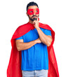 © Krakenimages.com - Young hispanic man wearing super hero costume serious face thinking about question with hand on chin, thoughtful about confusing idea