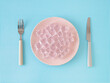 © Jakov Ilkoski - Creative layout made with pink plate, ice cubes, knife and fork on white and blue background. Minimal zero calorie food concept. Trendy healthy food with low calories funny idea. Flat lay.