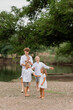 © Tina kids photo - children, brothers and sisters walk near the lake in the summer, a large family