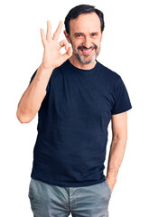 Wall Mural - Middle age handsome man wearing casual t-shirt smiling positive doing ok sign with hand and fingers. successful expression.
