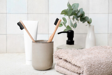 Wall Mural - Set of bath supplies with toothbrushes on table against light tile wall