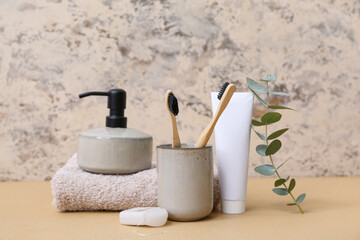 Wall Mural - Set of bath supplies with eucalyptus branch on color table against grunge background