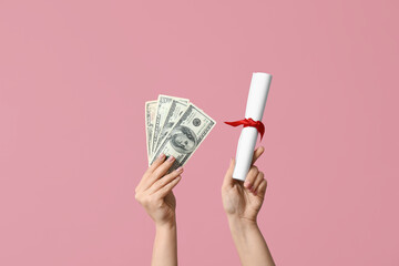 Wall Mural - Female hands holding diploma and money on pink background