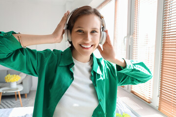 Sticker - Young woman in headphones listening to music at home