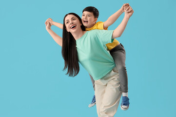 Canvas Print - Mother holding her little son on blue background