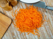 Fresh grated carrots lying on a wooden table. Top view..