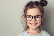 © InfiniteStudio - A child smiles with glasses on a plain background. Children's vision and eye health concept