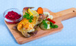 Roasted partridge with cranberry sauce and garnish of grilled carrots, cauliflower, tomato and onion