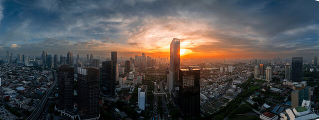 Wall Mural - Wide-angle panoramic view of a bustling city skyline bathed in the golden hues of sunset