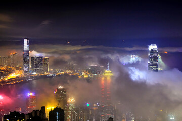Wall Mural - Misty cityscape at night with illuminated skyscrapers