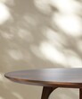 Round wooden table counter in dappled sunlight on beige wall for modern, luxury fashion, beauty, cosmetic, skincare, body care, product background 3D