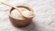 Psyllium husk in spoon on wooden bowl, fiber food for diet on linen table cloth background