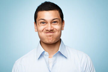 Poster - Funny face, portrait and silly with comic man in studio isolated on blue background for expression. Comedy, humor and joking with goofy or playful business person having fun in shirt for fashion