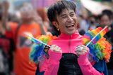 Fototapeta  - LGBTQ man having fun holding gay pride flag celebrate the annual Pride Parade, holding rainbow flags in two hands, celebrating LGBT pride month parade