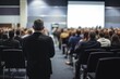 © SALEEM - Stylish business conference with audience in the hall and speaker, view from behind crowd of people sitting together during presentation or educational talk for company employees. Generative ai