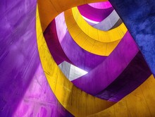 The Image Is A Colorful Spiral With Purple And Yellow Stripes