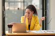 © crizzystudio - African office worker American working with laptop Tired financial documents having a headache at the office, feeling sick, migraine, feeling pressured, stressed, fatigue, office syndrome concept.
