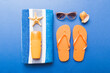 Summer holiday concept. Top view of beach towel, flip flop and sunscreen cream on table Top view with copy space for text
