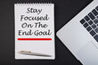 © Iryna - STAY FOCUSED ON THE END GOAL notepad writing concept on dark background with pen.