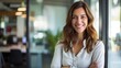 © Ameer - Confident entrepreneur: smiling businesswoman in casual attire poses in modern workspace environment
