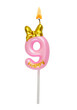 Pink birthday candle with gold bow isolated on white background. Number 9.