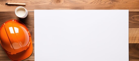 Fototapete - A top down view of a brown wooden table displaying a white sheet of paper alongside an orange safety helmet a notepad or notebook and a cup of coffee The image offers ample space for text or any desi